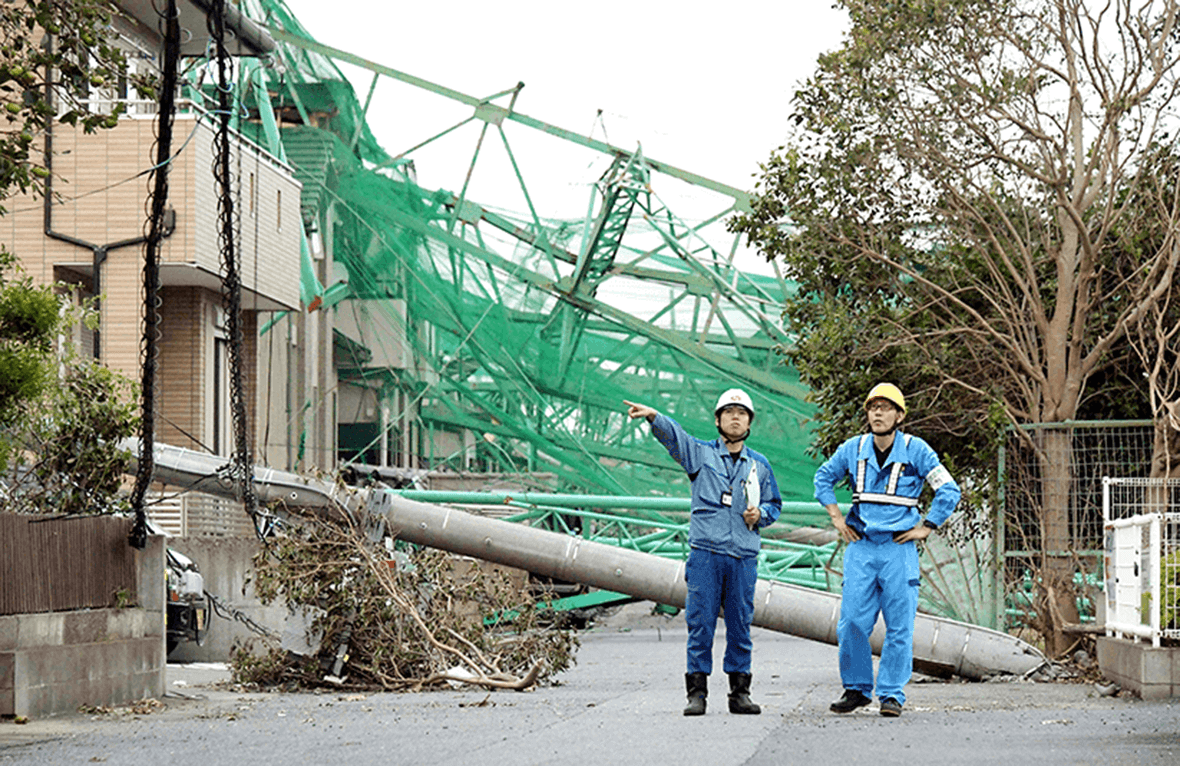 ゴルフ練習場のフェンスが倒壊し、住宅や配電設備が被害を受けた現場で状況を確認する